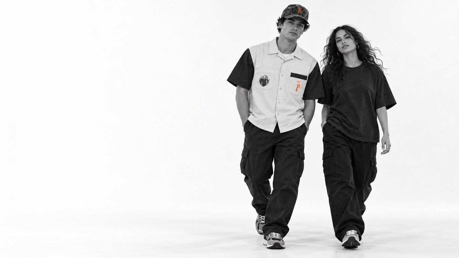 Two young adults walking in Pentecost Avenue streetwear in a white studio
